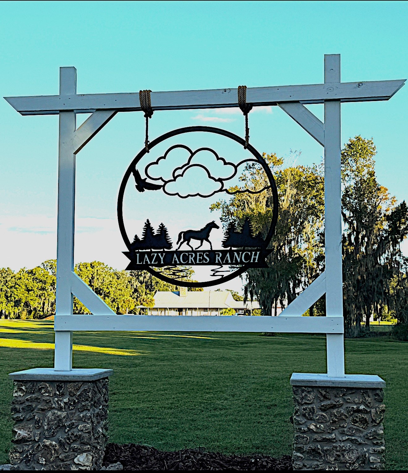 Lazy Acres Ranch entrance sign with horse silhouette framed by Spanish moss oak trees