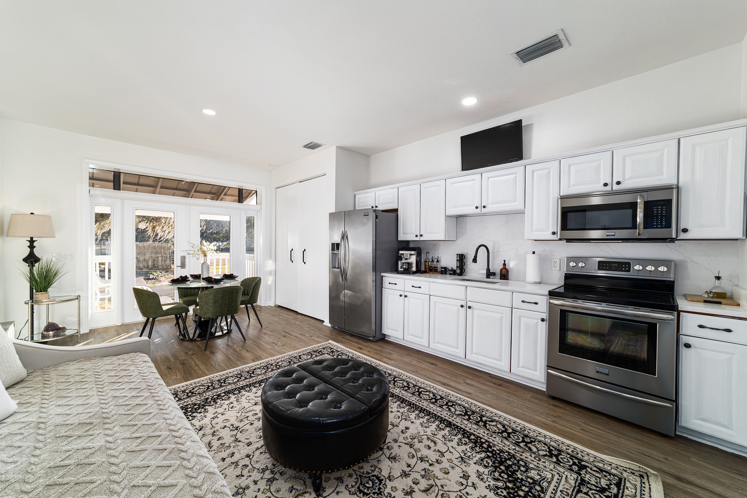 Open-concept kitchen and living area with white cabinetry and dining nook