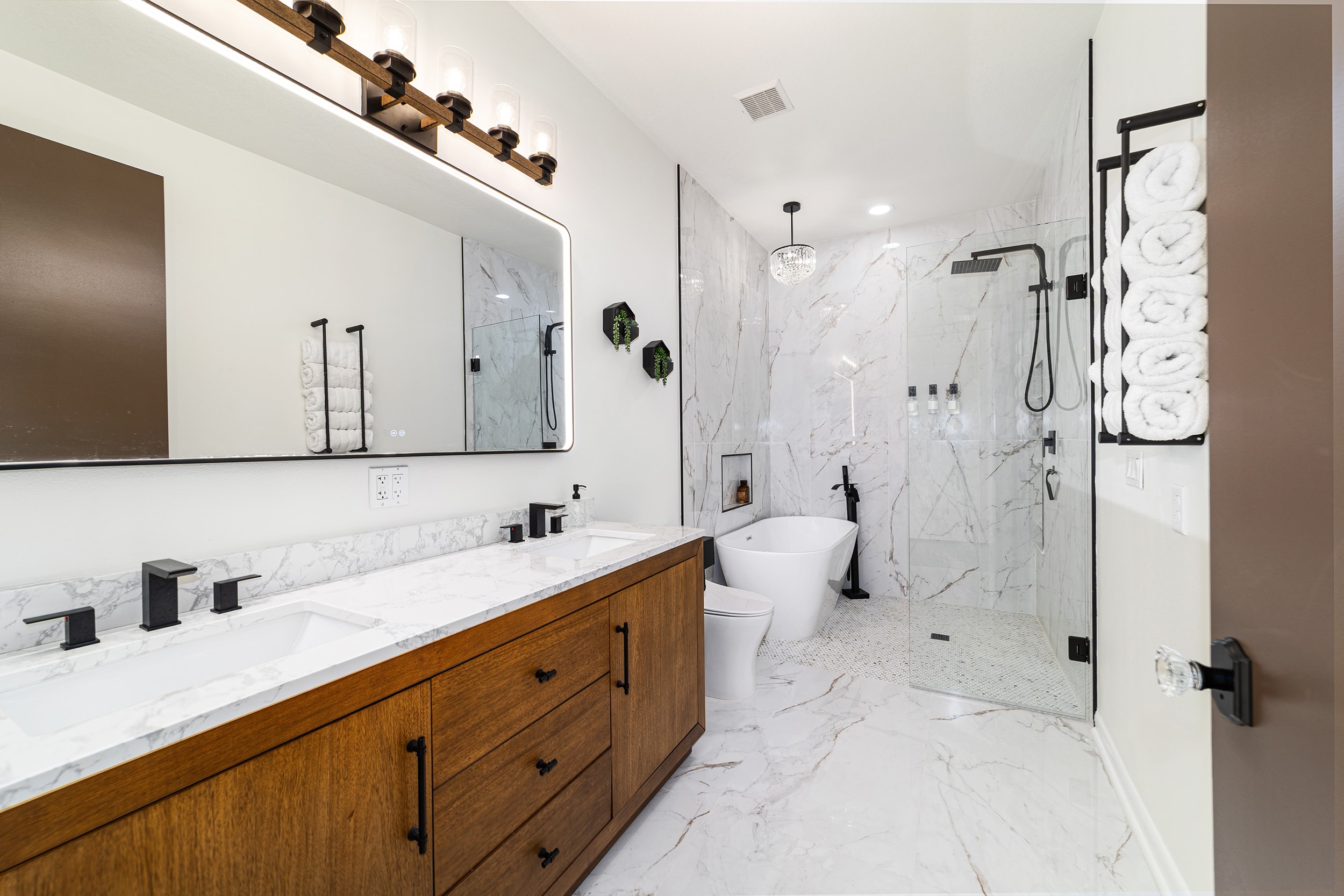 Spa-style bathroom with marble walls, freestanding tub, and walk-in shower