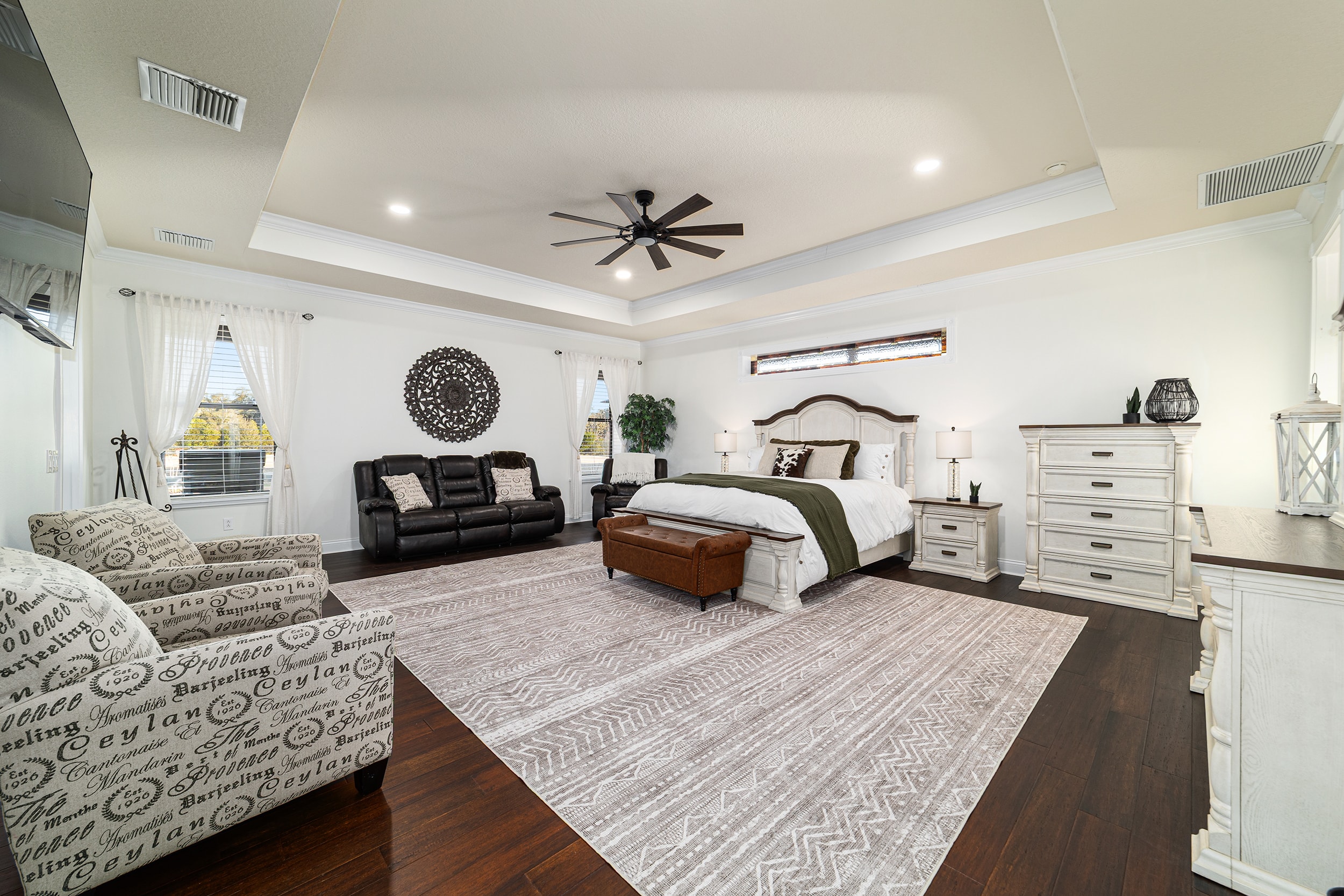 Spacious master suite with tray ceiling and elegant furnishings