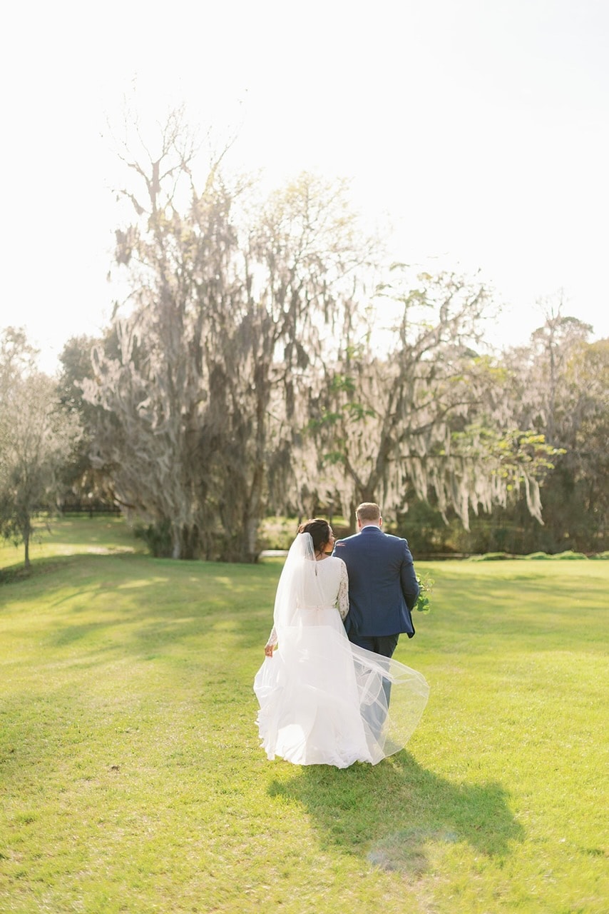Bride and groom portrait under the Spanish moss tree-lined avenue at The Ranch