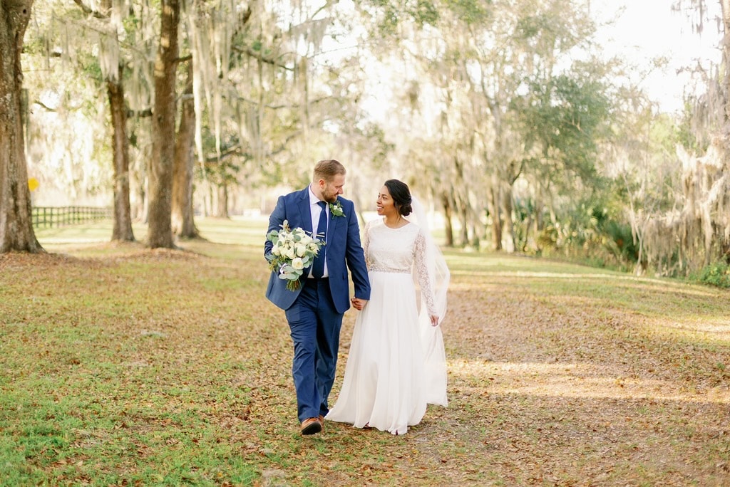 Bride and groom embracing under the canopy of Spanish moss oak trees at The Ranch