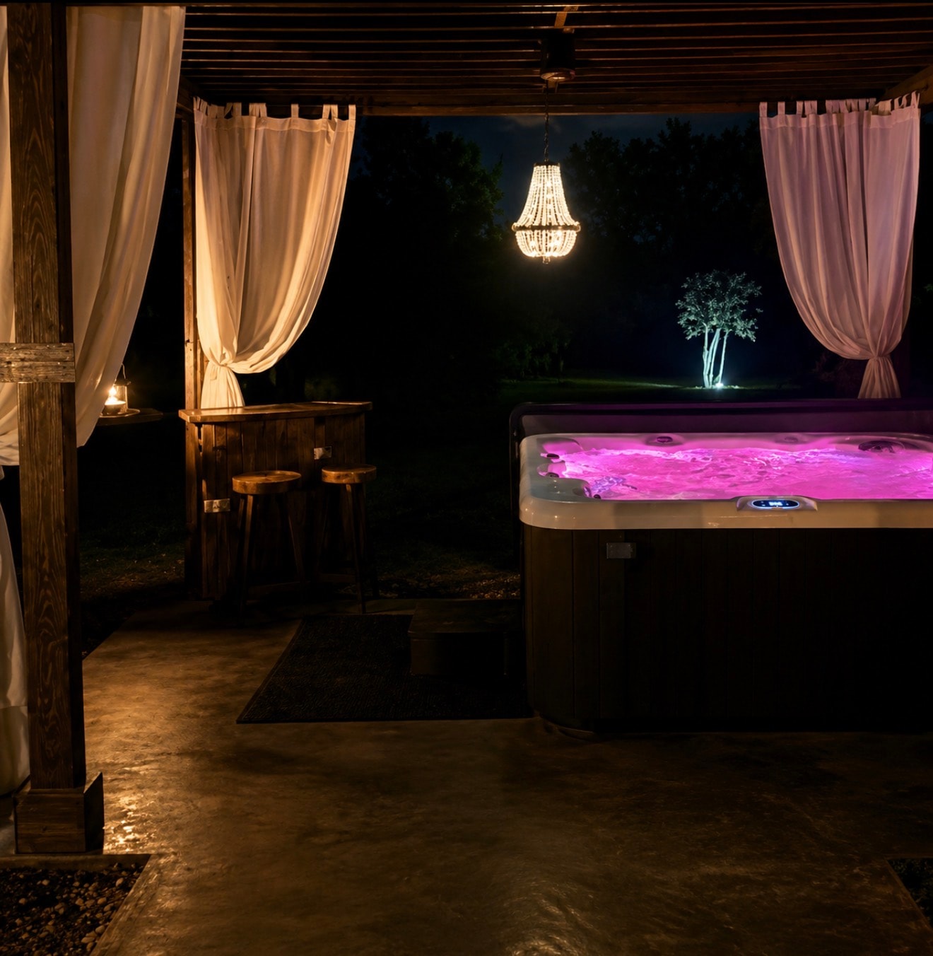 Private hot tub with chandelier and draping curtains at The Ranch at night